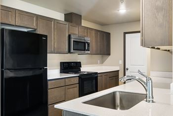 An empty kitchen with a sink and a refrigerator
